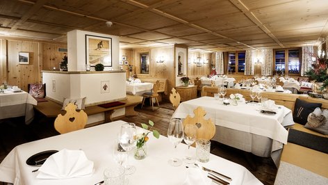 Cozy restaurant interior featuring wooden walls and elegantly set tables for dining