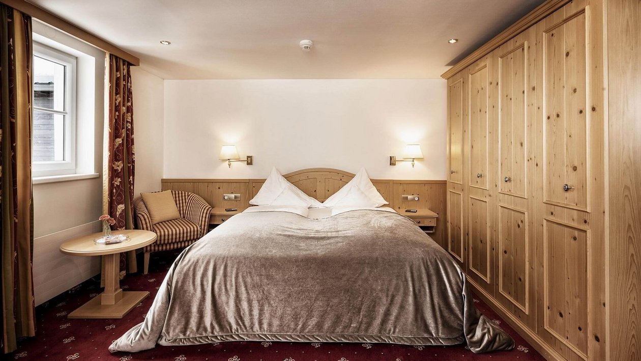 Elegantes Schlafzimmer für erholsame Nächte Ein geschmackvoll eingerichtetes Hotelzimmer mit großem Bett und Holzdetails sowie sanfter Beleuchtung.