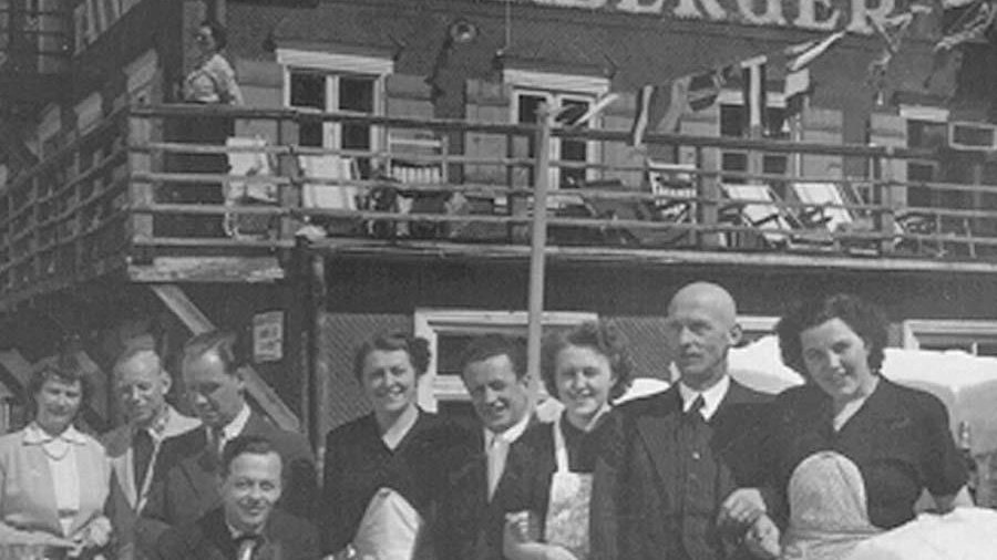 The founder of the Hotel Tannbergerhof An old black-and-white photograph showing a large group of people with the husband and wife owners of the hotel in the centre