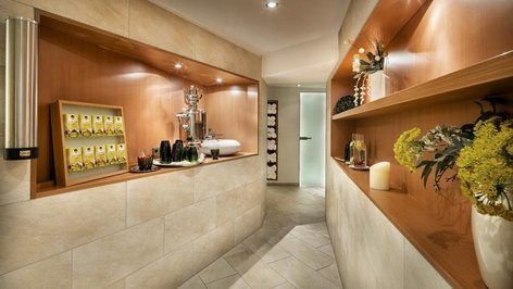 The relaxation area with decorative wooden shelves, drinks station and tiled walls at the Tannbergerhof in Lech © Foto Lehmann