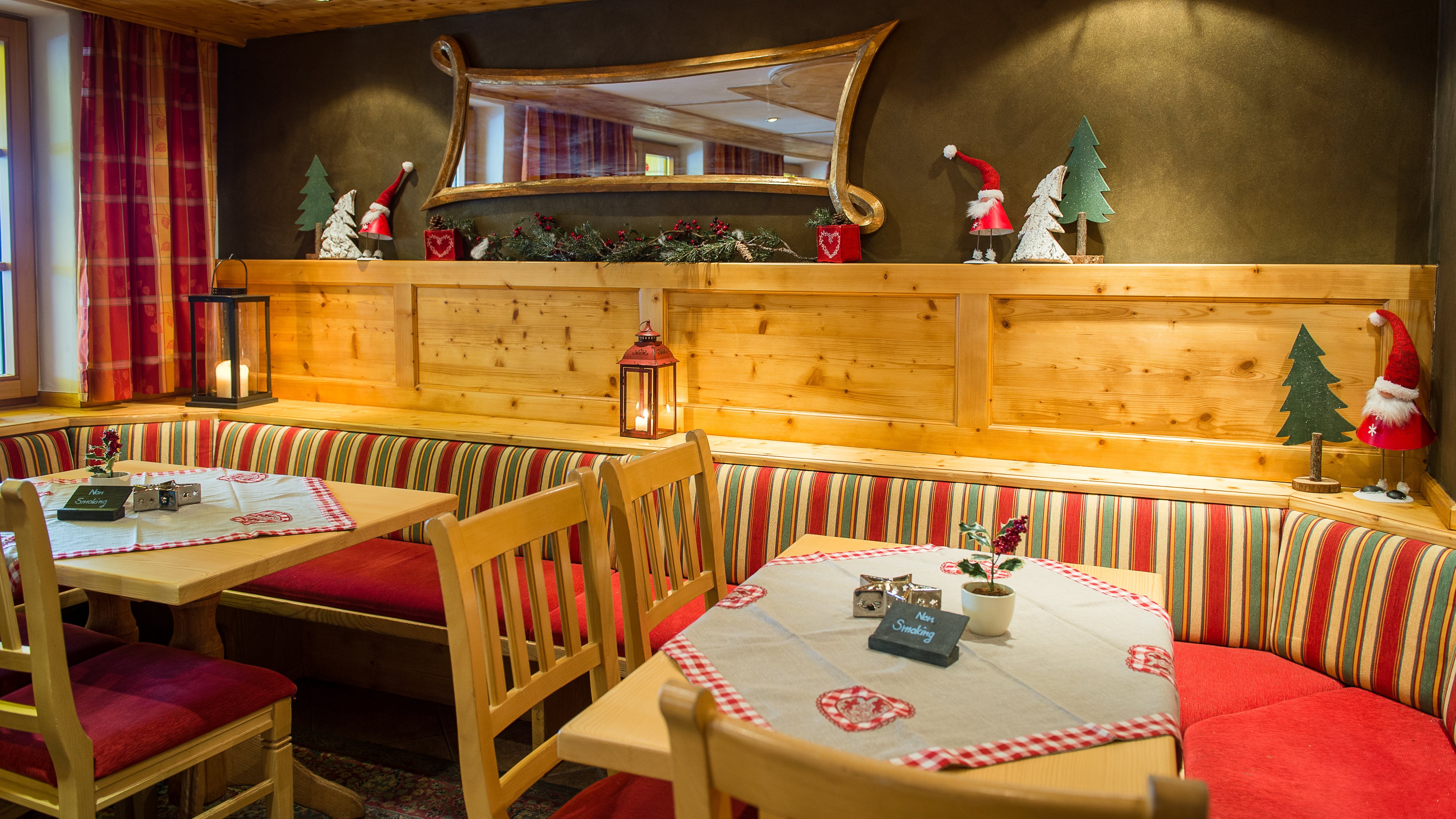 Innenansicht eines festlich dekorierten Restaurants mit Holzmöbeln und Weihnachtsornamenten