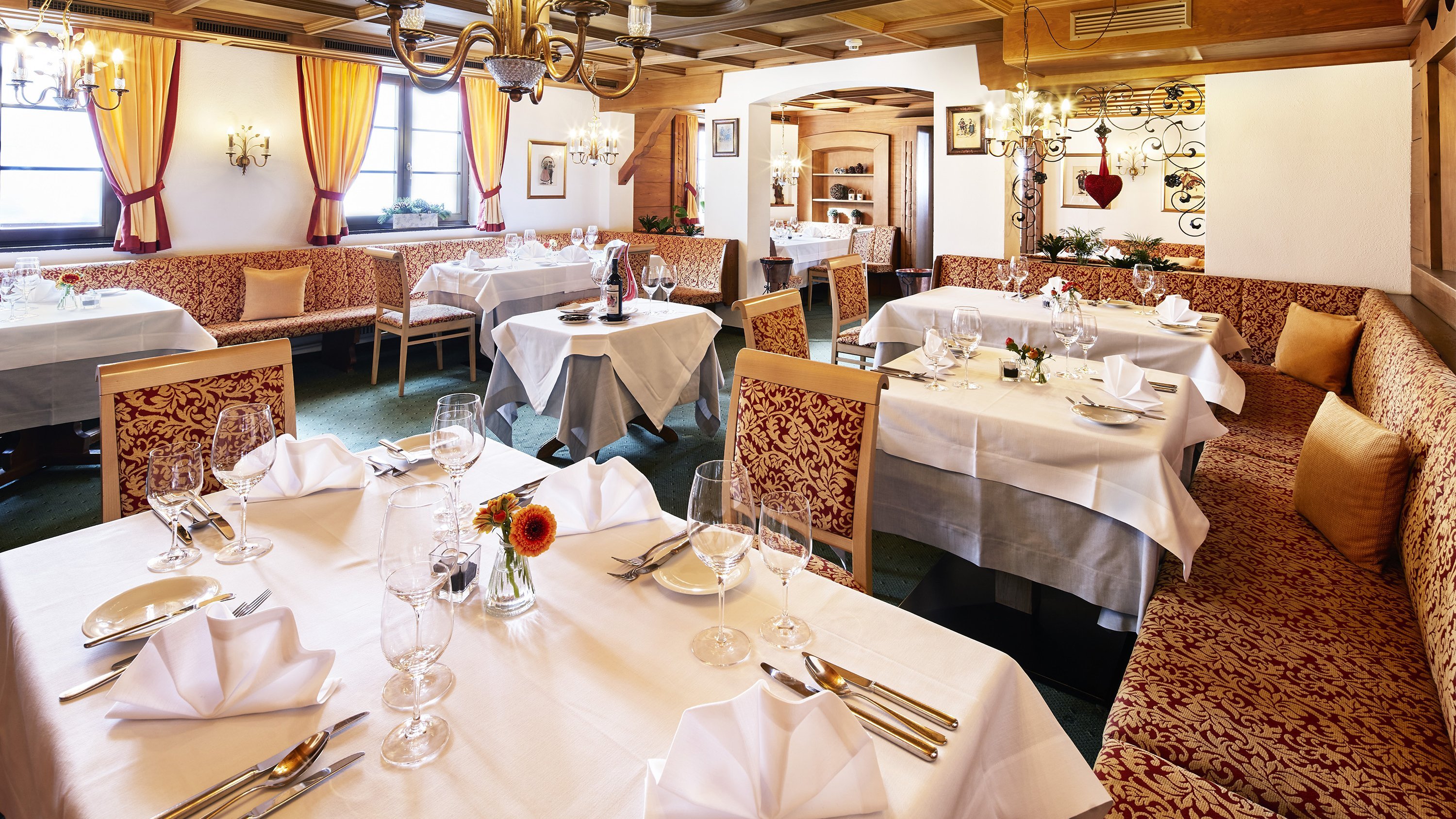 Innenansicht eines stilvoll dekorierten Restaurants mit Tischen und sanfter Beleuchtung