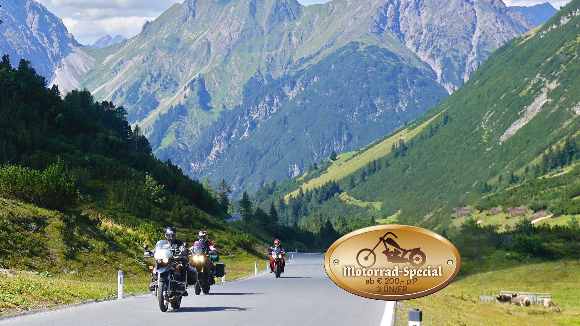 Group of motorcyclists riding along a winding road through mountains and greenery