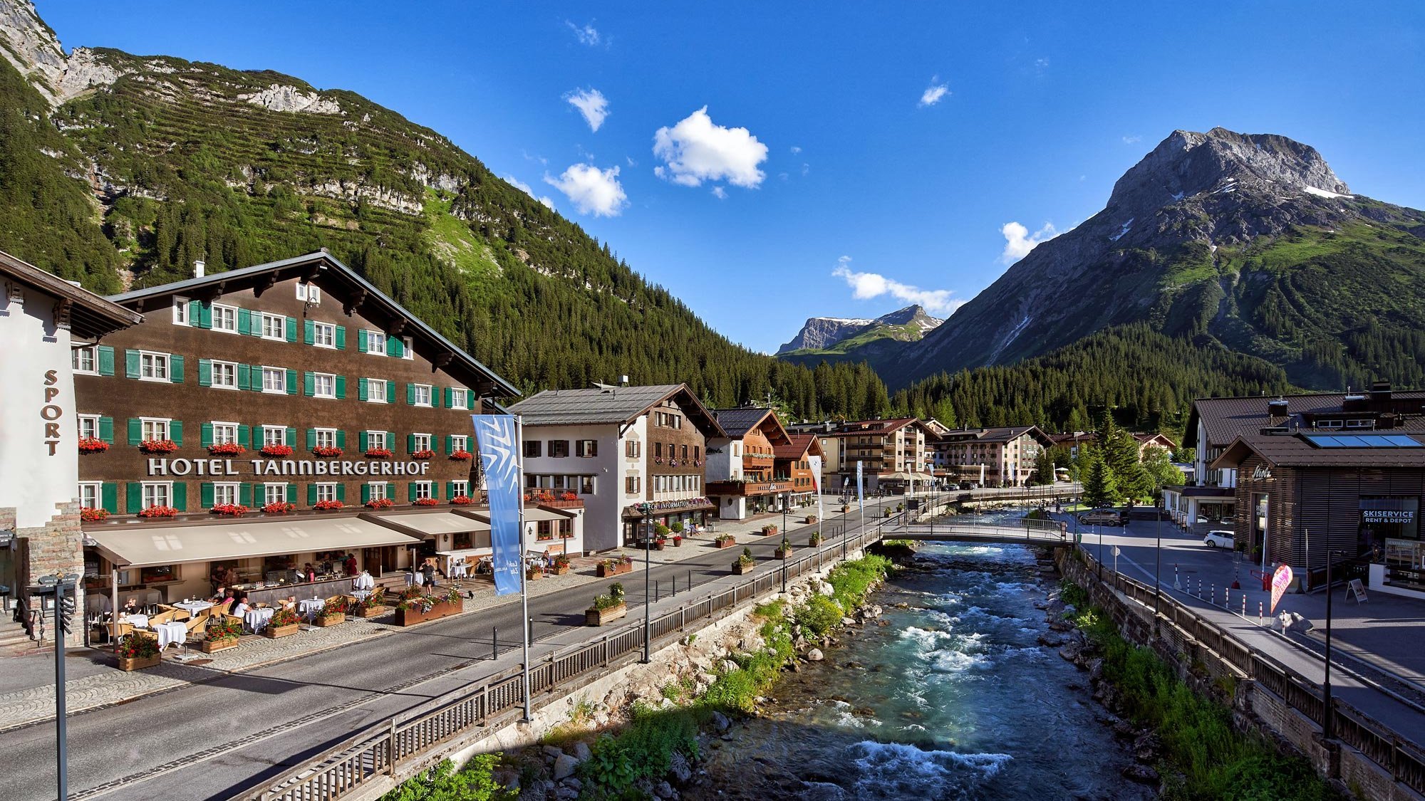 Hotel Tannbergerhof in einer bergigen Landschaft mit einem Fluss und umgebender Vegetation