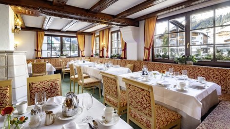 Restaurant interior featuring elegantly set tables and large windows revealing mountains