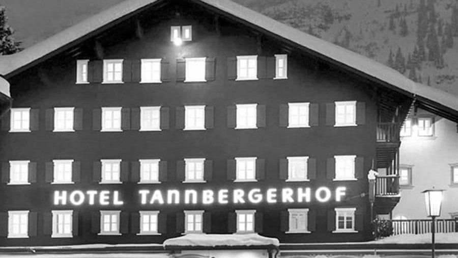 Tannbergerhof Hotel in Winter Exterior view of Tannbergerhof Hotel with dark facade and snowy mountain background
