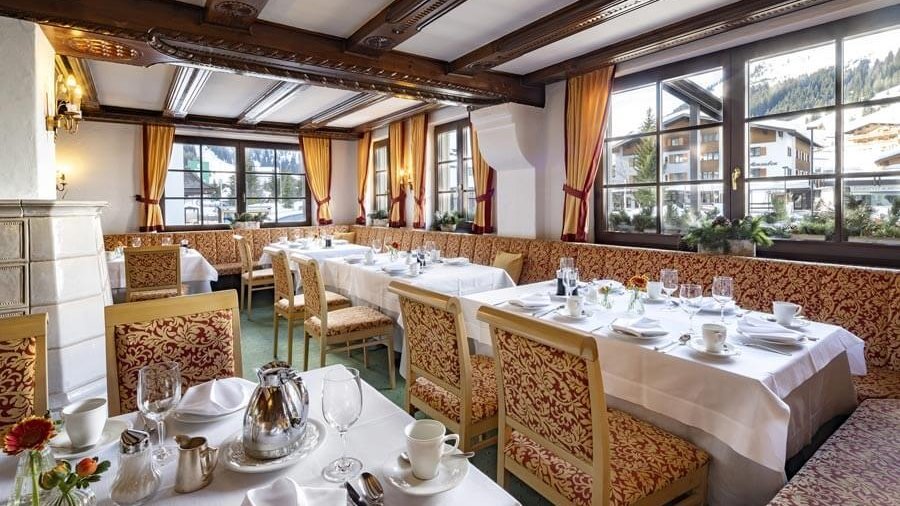 The dining room with laid tables, large windows and traditional furnishings at the Tannbergerhof in Lech © Foto Lehmann