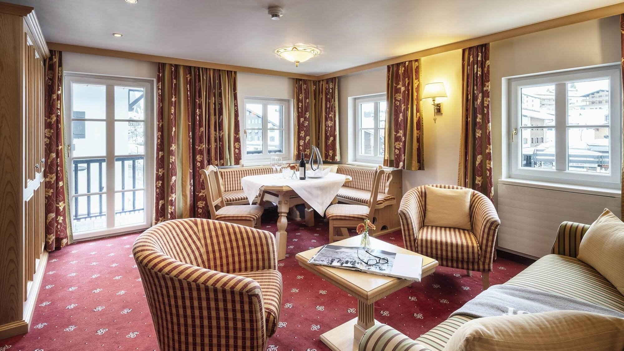 Geräumige Hotel-Suite mit gemütlichem Wohnbereich und großen Fenstern für viel Tageslicht