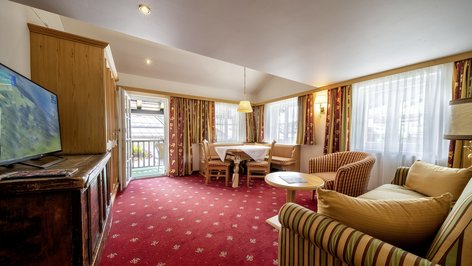 Hotel room featuring a comfortable living area with a television and dining table
