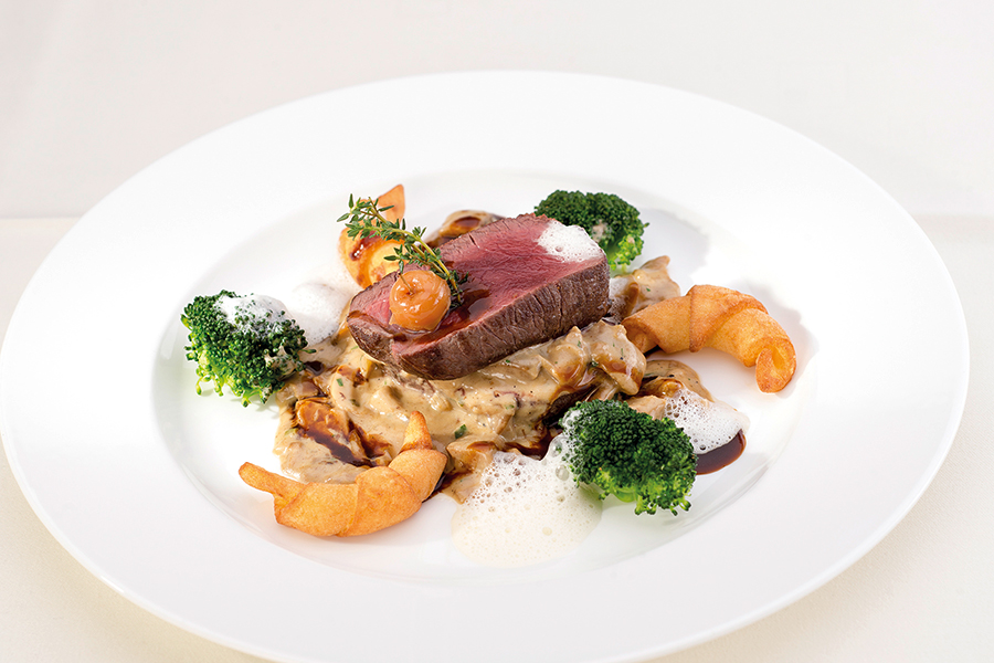 Rinderfilet auf Pilzragout mit Brokkoli und Blätterteiggebäck auf einem weißen Teller im Restaurant im Tannbergerhof in Lech © Foto Lehmann