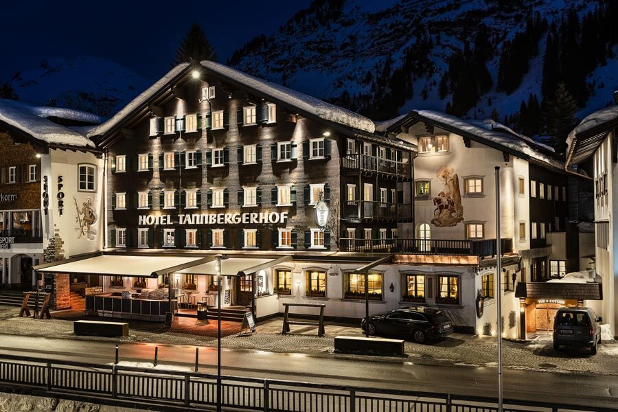 Das Hotel Tannbergerhof in Lech erstrahlt in der Nacht, umgeben von schneebedeckten Vorarlberger Bergen © Foto Lehmann